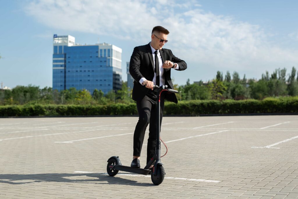 Embedos_young-businessman-with-electric-scooter-standing-front-modern-business-building